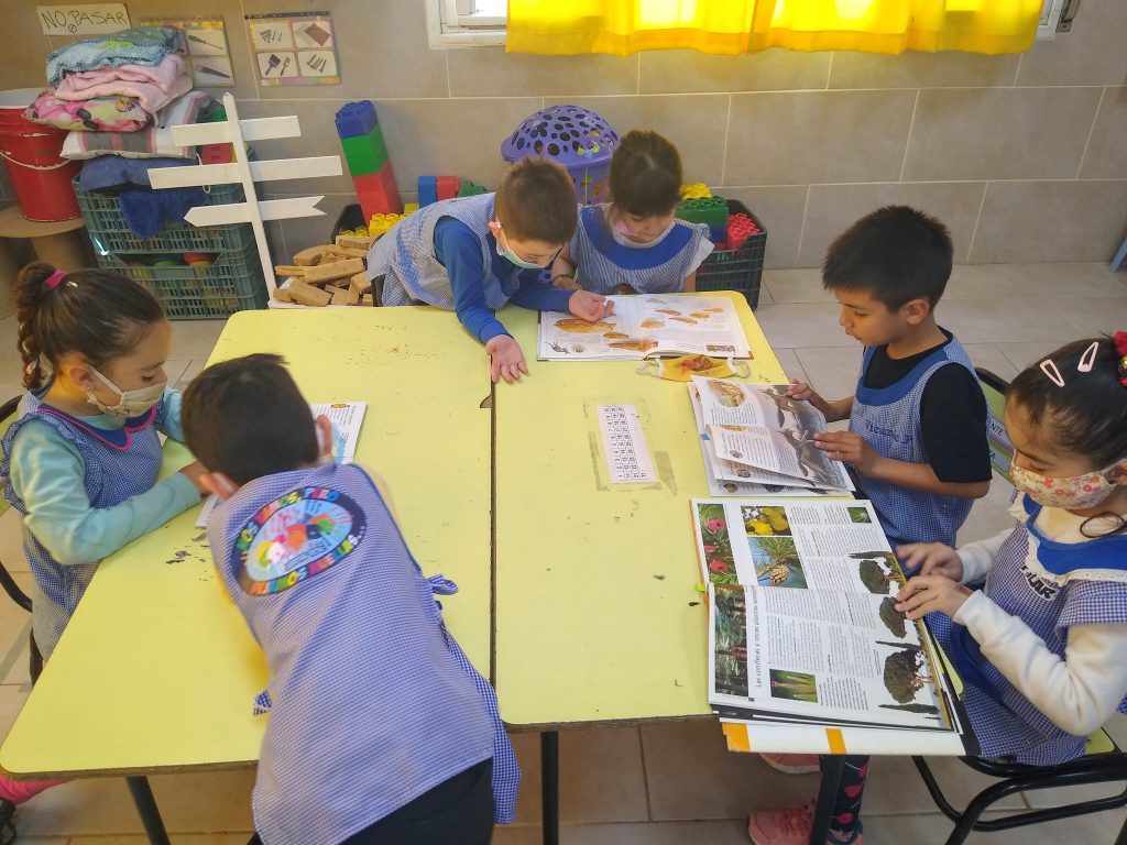 Niñas y niños elaborando el folleto sobre la mesa